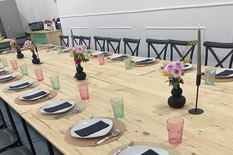 Mesa larga de madera con vajilla completa